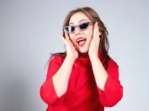 photographe studio portrait femme expressive habillée en rouge avec des lunettes de soleil