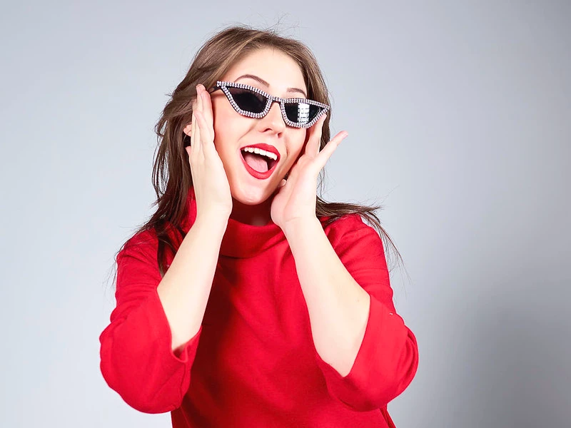photographe studio portrait femme expressive habillée en rouge avec des lunettes de soleil