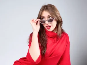 photographe studio portrait femme assise habillée en rouge avec des lunettes de soleil